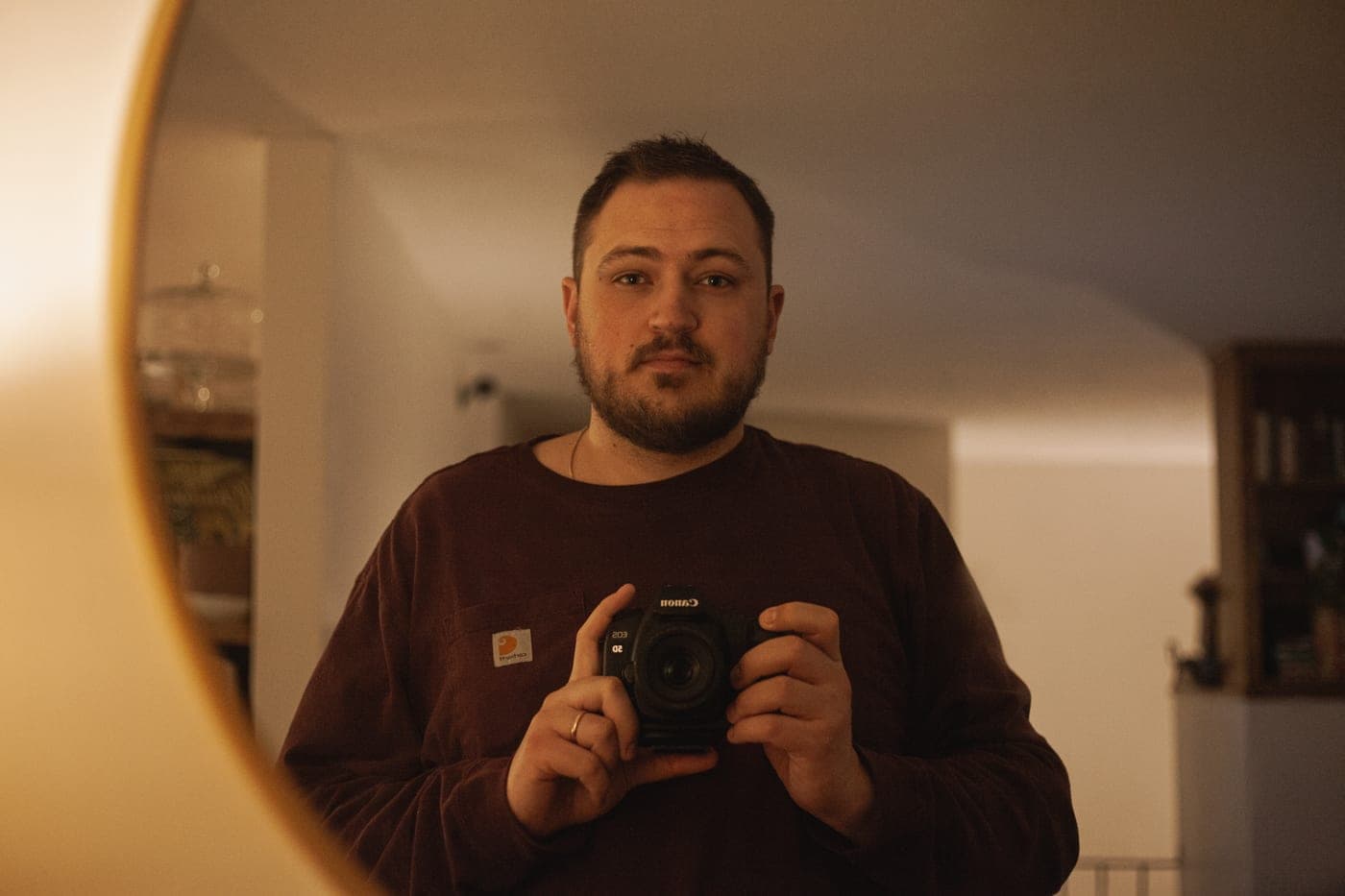 Samuel holding a camera, reflected in a mirror
